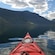 A kayak on calm fjord waters surrounded by mountains in Bergen, Norway